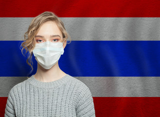 Young woman wearing a face mask with Thai flag. Flu epidemic and virus protection concept