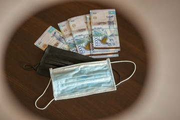 Medical antibacterial masks against coronavirus and money.