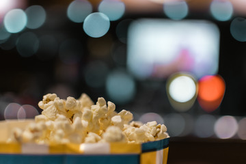 Cubo de palomitas con una pantalla de cine desenfocada