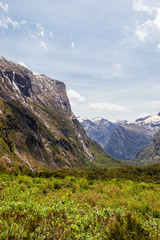 Obraz premium Sheer cliffs and green valley on the way to Fiordland. South Island, New Zealand