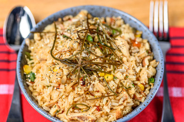 Fried Rice in a blue texured bowl on a wooden table.