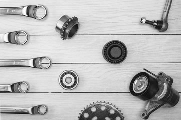 The layout of auto parts and car repair tools. Wooden white background.