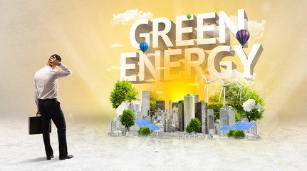 Rear view of a businessman standing in front of GREEN ENERGY inscription, Environmental protection concept