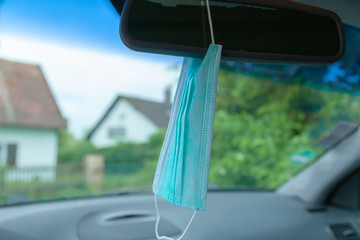 Mundschutzmaske gemäß einem neuen Trend am Rückspiegel des Autos befestigt