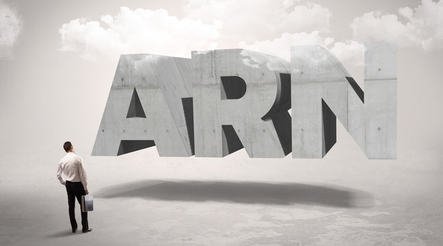 Rear view of a businessman standing in front of ARN abbreviation, modern technology concept