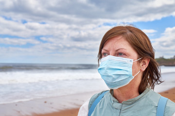 Pretty lady wearing a protective facemark on the beach during the covid19 - Coronavirus Pandemic....