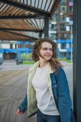 Happy curly-haired girl in jeans clothes