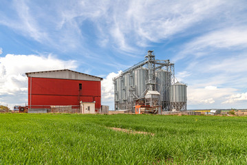 Fototapeta na wymiar Industrial silos under blue sky, in the field 