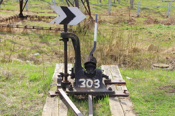 Railway arrow in black with a lever and pointer in Russia. The device for the transfer of rails at intersections for trains. Technical element of the railway industry.