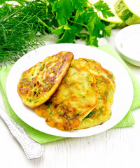 Pancakes of zucchini on light wooden board