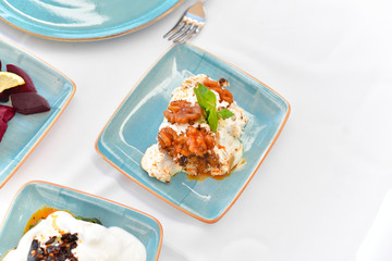 appetizers with yogurt, tomatoes, cheese, lemon, greens, mussels, olives, snacks on white background, ready for service, should be used as background.