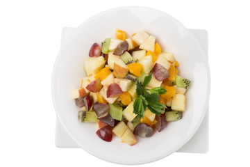 Mixed fruit salad in the white bowl.