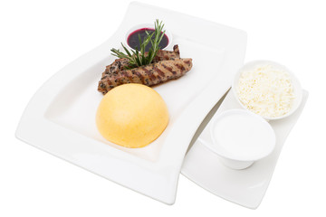 Beef tenderloin and a hominy with white cheese.