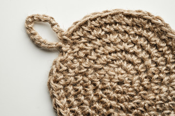 Napkin knitted from jute rope on a white background. Handwork.
