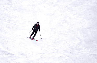 Fototapeta na wymiar Full length of skier skiing on fresh powder snow. Man skier running downhill on sunny Alps slope