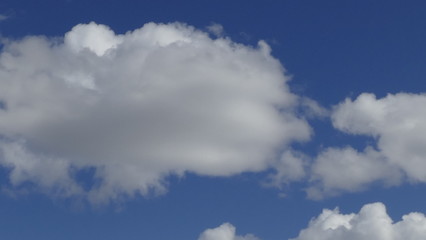 Naklejka na ściany i meble white fluffy clouds on a blue sky