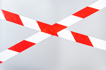 Red white signal striped interdictory tape. Striped line isolated on gray background. Plastic warning tape. 