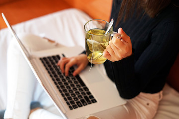 Woman drinking tea while working at home. Tea and work concept.