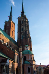 Fototapeta premium church, architecture, cathedral, tower, city, building, europe, old, town, landmark, religion, gothic, travel, poland, tourism, sky, historic, catholic, history, medieval, clock, historical,wroclaw