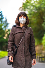 Lifestyle of a Caucasian brunette with short hair and a protective mask for the coronavirus. First walks of the uncontrolled Covid-19 pandemic