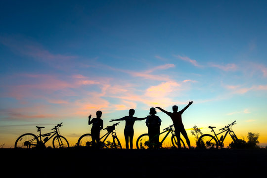 Action of  cyclist and Bicycle silhouettes on the dark background of sunsets