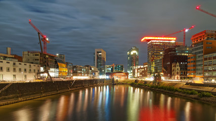 Dusseldorf harbor at night. Beautifully lit urban architecture. The city lights are reflected in the river Rhein.