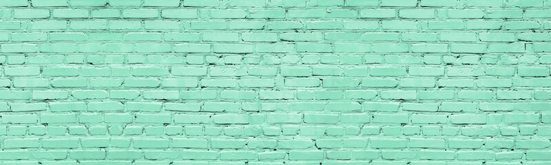 Mint color painted brick wall wide texture. Old pastel green rough brickwork background