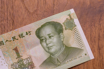 The Currency of the China - Close up of a green one remminbi or yuan note on a brown table background. Money exchange.