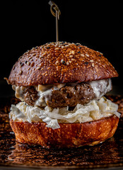 Traditional beef burger with vegetables on dark background