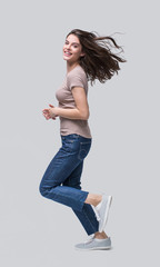 	
Laughing young woman running, having fun and enjoying life, beautiful joyful girl full length portrait. Studio shot, cut out, Isolated on grey background