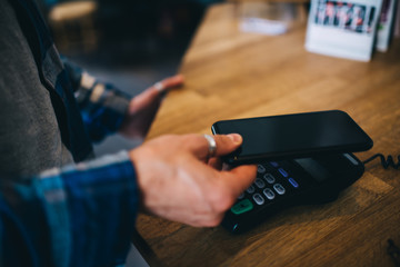 Unrecognizable male paying with smartphone