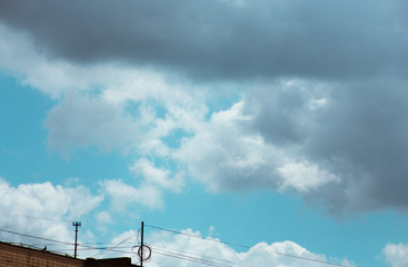 Fluffy clouds cover the summer blue sky