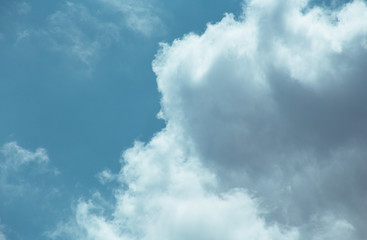 Fluffy clouds cover the summer blue sky
