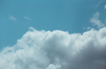 Fluffy clouds cover the summer blue sky