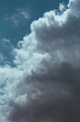 Fluffy clouds cover the summer blue sky
