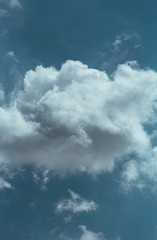 Fluffy clouds cover the summer blue sky