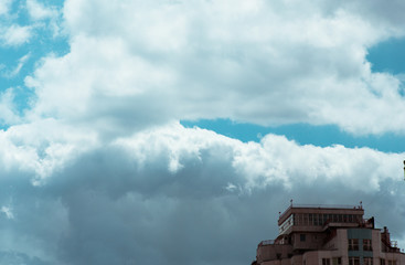Fluffy clouds cover the summer blue sky
