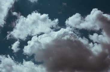 Fluffy clouds cover the summer blue sky