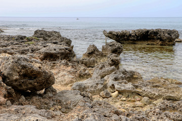 Rocks in the sea in full May on the coast of Taranto, Puglia, Italy