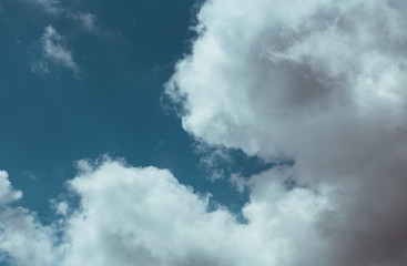 Fluffy clouds cover the summer blue sky