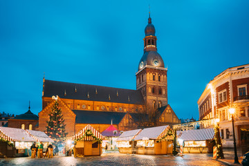 Fototapeta na wymiar Riga, Latvia. Christmas Market On Dome Square With Riga Dome Cathedral. Christmas Tree And Trading Houses. Famous Landmark At Winter Evening Night In Illuminations Light
