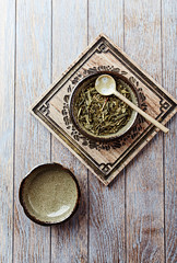 Dried Green Tea Leaves on Bright Background. Top view.