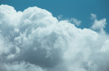 Fluffy clouds cover the summer blue sky
