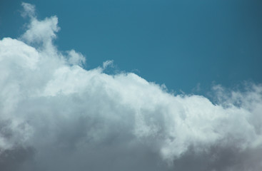 Fluffy clouds cover the summer blue sky