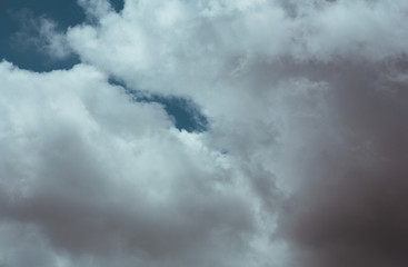 Fluffy clouds cover the summer blue sky