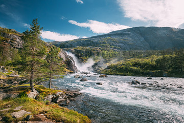 Kinsarvik, Hordaland, Norway. Waterfall Nykkjesoyfossen In Hardangervidda Mountain Plateau. Summer Sunny Day. Height Of 49 m. Famous Norwegian Landmark And Popular Destination