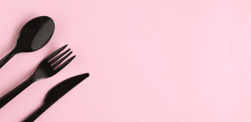 Forks, Spoons and Knives on pink background. Plastic cutlery, ecology, environmental pollution by...