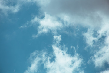 Fluffy clouds cover the summer blue sky