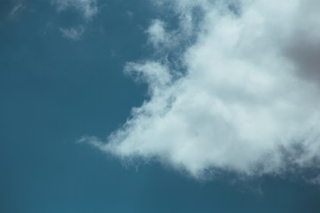 Fluffy clouds cover the summer blue sky