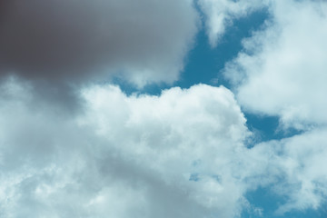 Fluffy clouds cover the summer blue sky